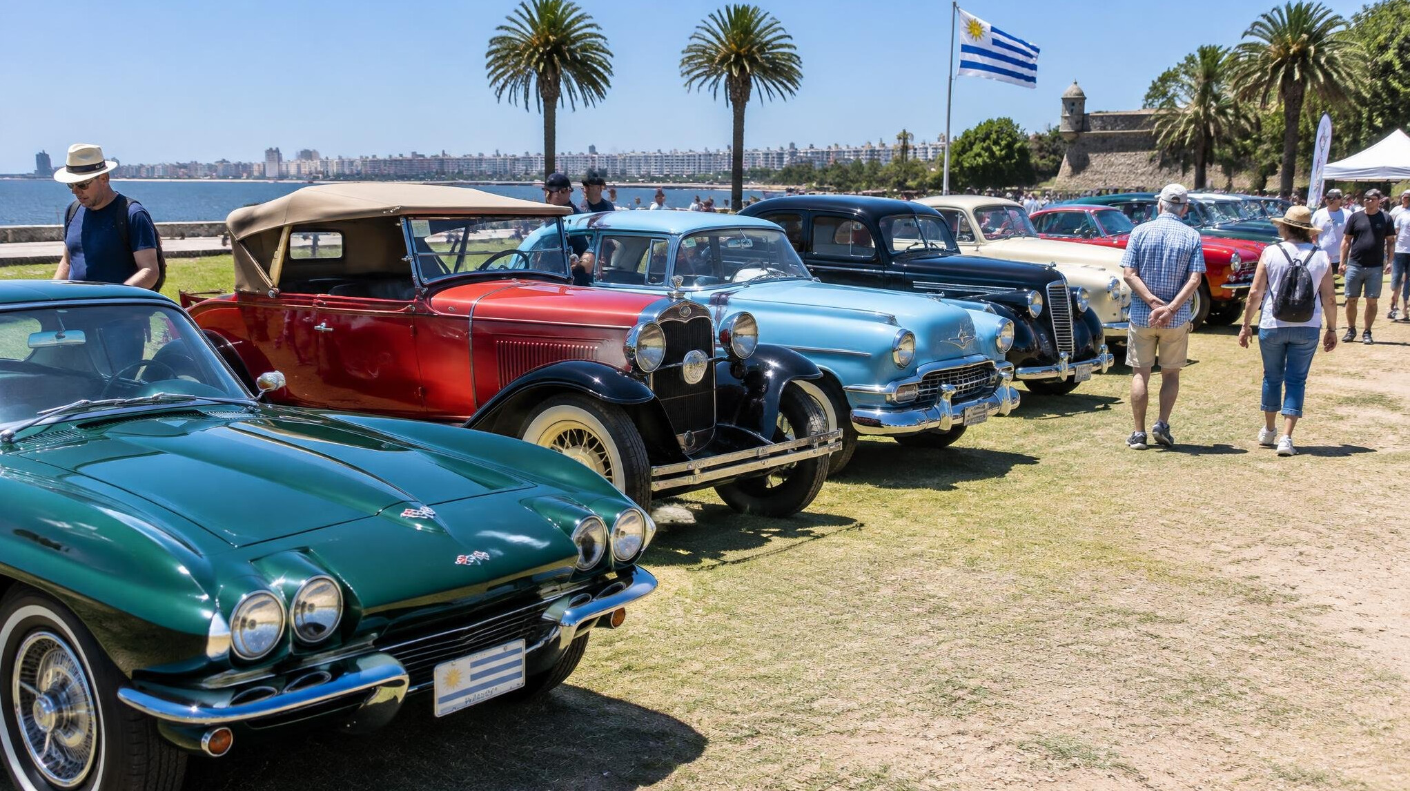 Several classic cars lined up together at a vintage car rally gathering