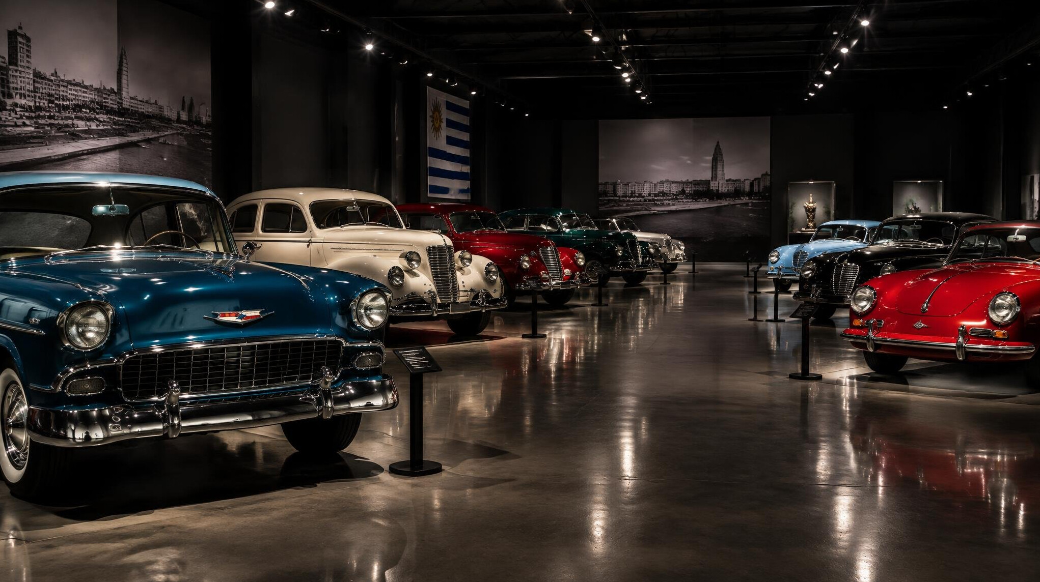 Rows of restored vintage automobiles displayed inside a museum exhibition hall